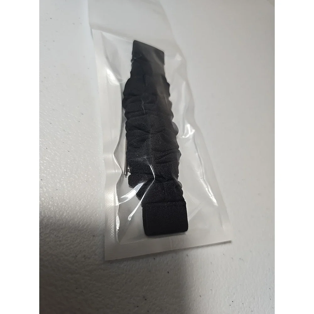 Scrunchie-style watch band for a fitness tracker, made of a black, ruched fabric